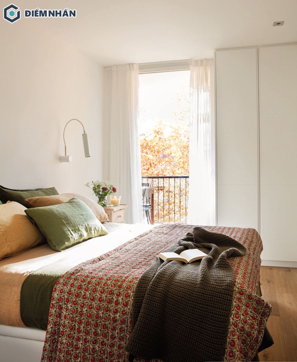 Phòng ngủ đơn giản với màu trắng và điểm nhấn là chiếc giường nhiều màu sắc